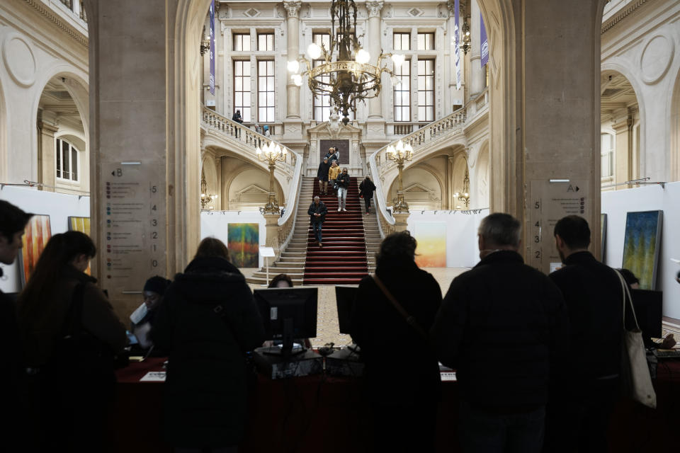 People wait to register to vote in a citywide mini-referendum: "For or against self-service scooters in Paris?" at the city hall of the 10th district of Paris, Sunday, April 2, 2023. The wheels may be about to come off Paris' experiment with for-hire electric scooters. That's if Parisians vote on Sunday to do away with the 15,000 opinion-dividing micro-vehicles. (AP Photo/Thibault Camus)