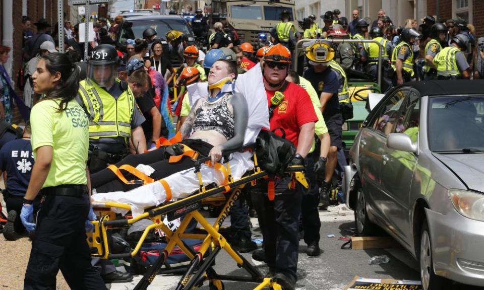 Rescue personnel help injured people after a car ran into a large group.