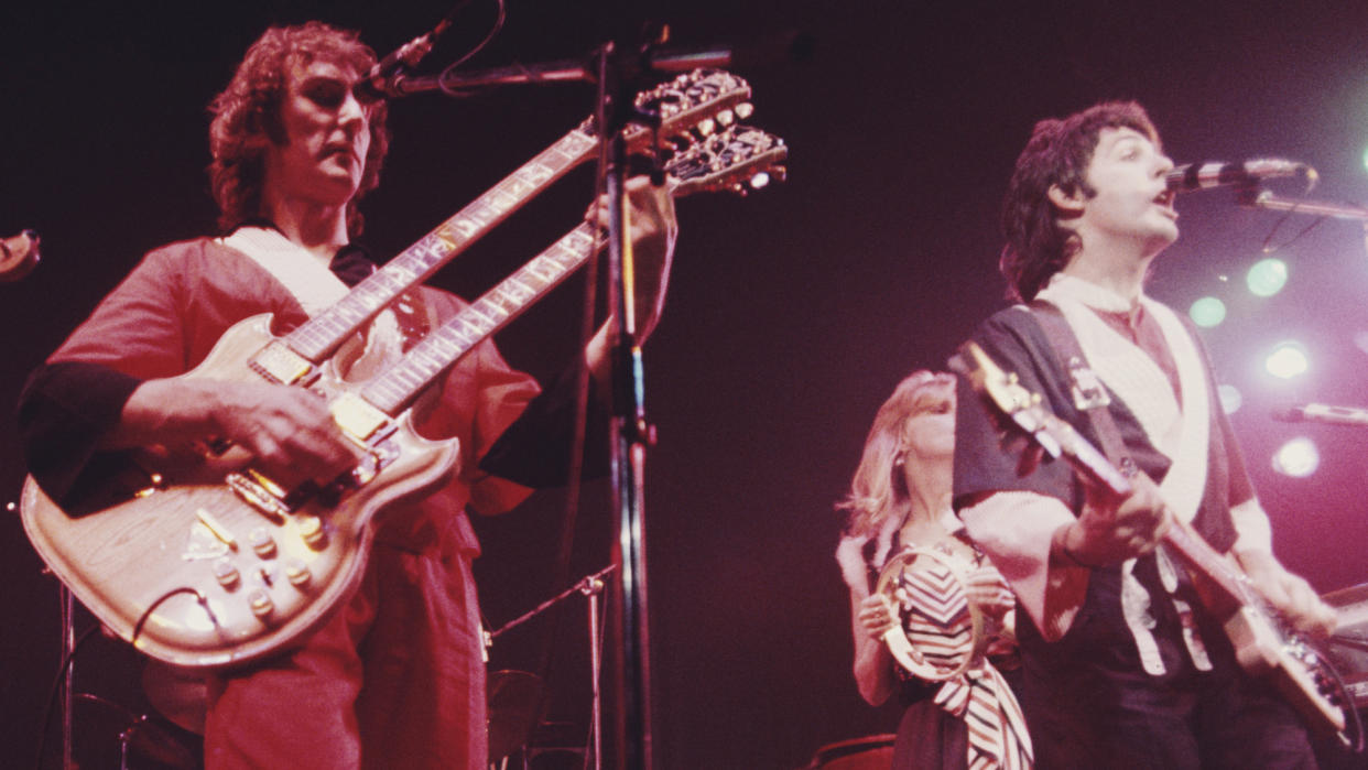  Denny Laine (left) and Paul McCartney perform onstage in 1976. 