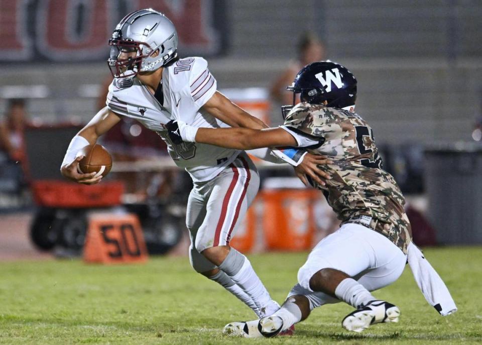 Torres High’s quarterback Jose Soriano, left, escapes the rush by Washington Union’s Joel Ramos, right, Friday, Sept. 1, 2023 in Easton.