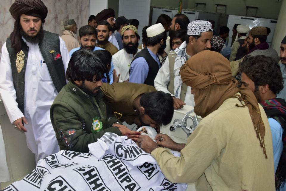 People mourn as they gather around a body of their relative, who was killed in a bomb explosion, at a hospital, in Quetta, Pakistan, Friday, Sept. 29, 2023. A powerful bomb exploded at a rally celebrating the birthday of Islam's Prophet Muhammad in southwest Pakistan on Friday, killing multiple people and wounding dozens of others, police and a government official said. (AP Photo/Arshad Butt)