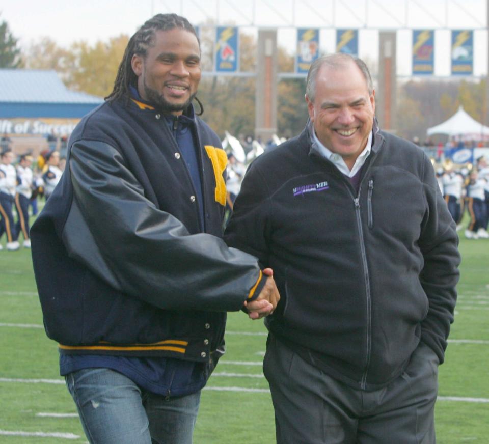 Former Kent State quarterback Joshua Cribbs (left) is congratulated by former head coach Dean Pees after Cribbs' jersey was retired in a halftime ceremony during a game vs. Ball State, Saturday, Oct. 30, 2010, at Dix Stadium.