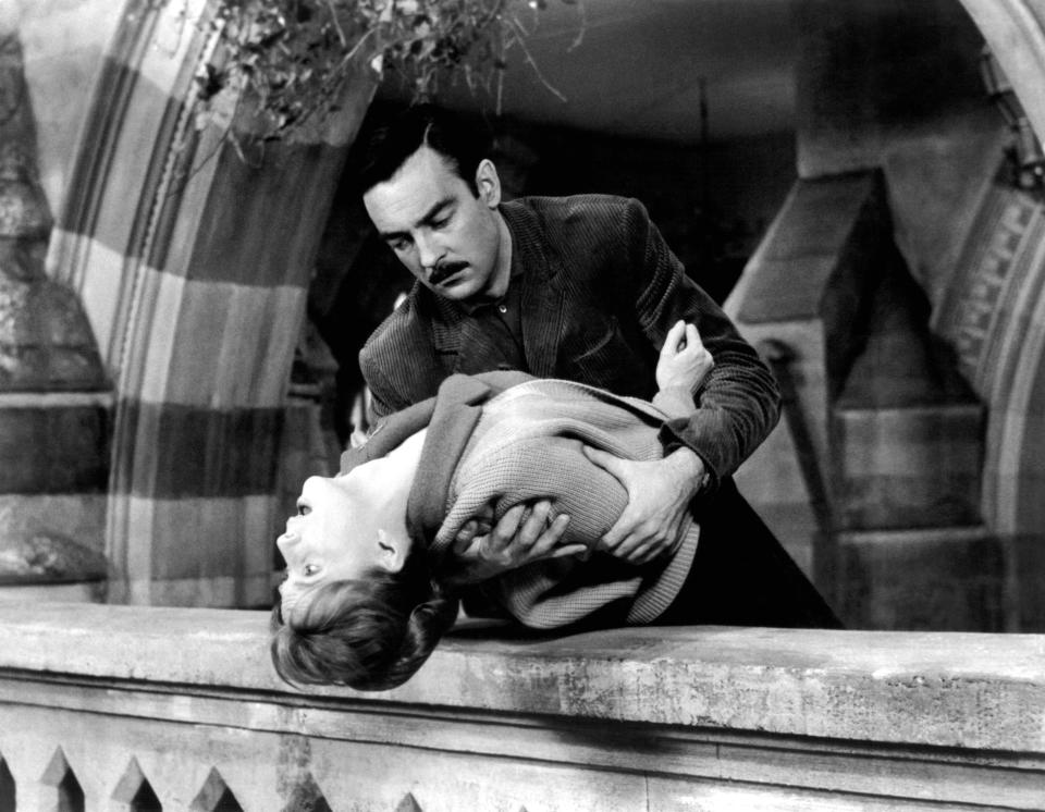 Richard Johnson holds Julie Harris over a railing