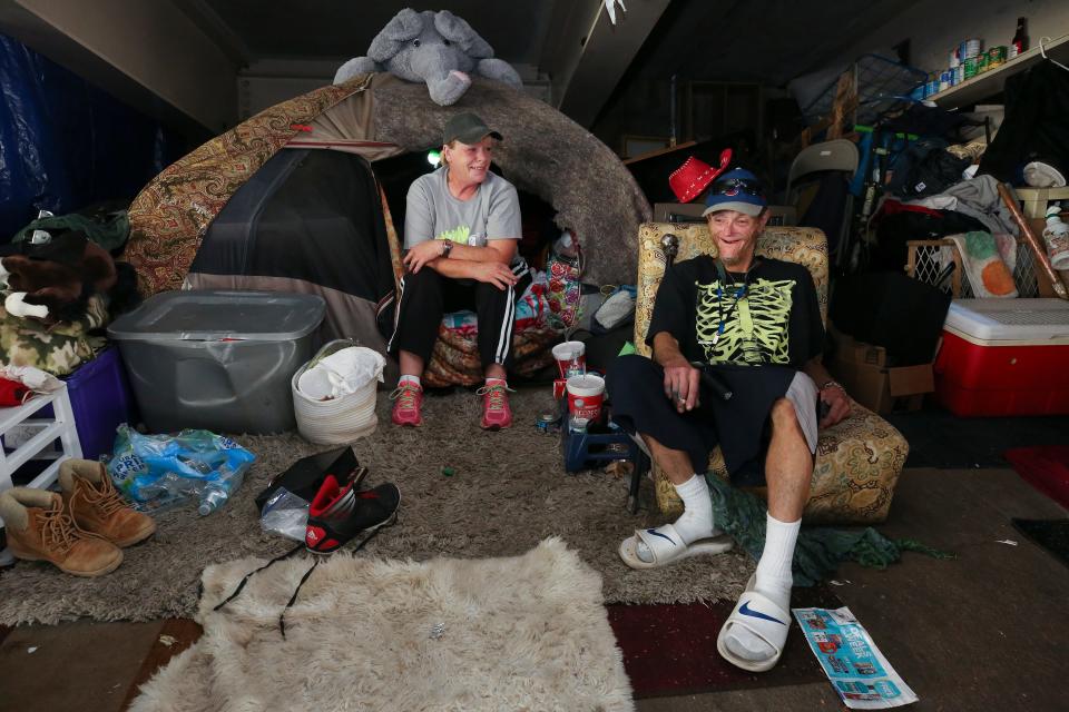Brent Spradlin, right, relaxes with his friend Kim Morrow in a homeless camp beneath the I-65 overpass at Brook and Breckinridge streets.  They live in tents next to each other.  The city has posted signs that they will be removing the camps starting July 12.
July 8, 2019