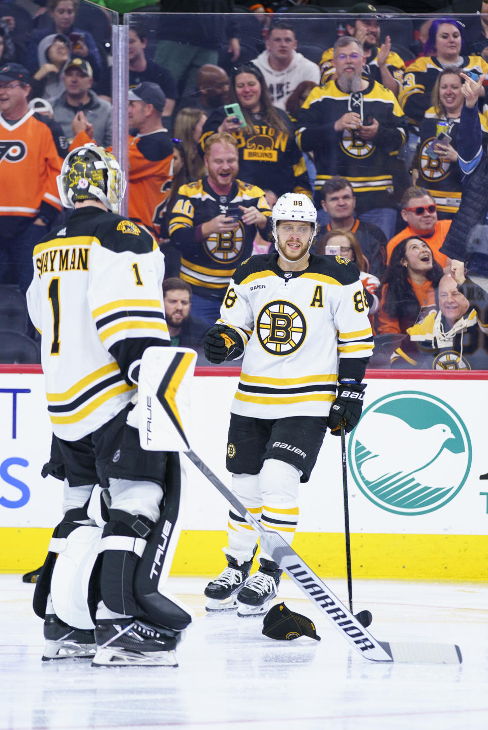 Boston Bruins' David Pastrnak, right, celebrates his third goal with Jeremy Swayman, left, during the third period of an NHL hockey game against the Philadelphia Flyers, Sunday, April 9, 2023, in Philadelphia. The Bruins won 5-3.(AP Photo/Chris Szagola)