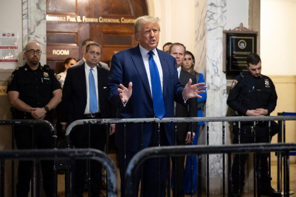 Donald Trump speaks to reporters after leaving Judge Arthur Engoron’s courtroom on 25 October. (AP)