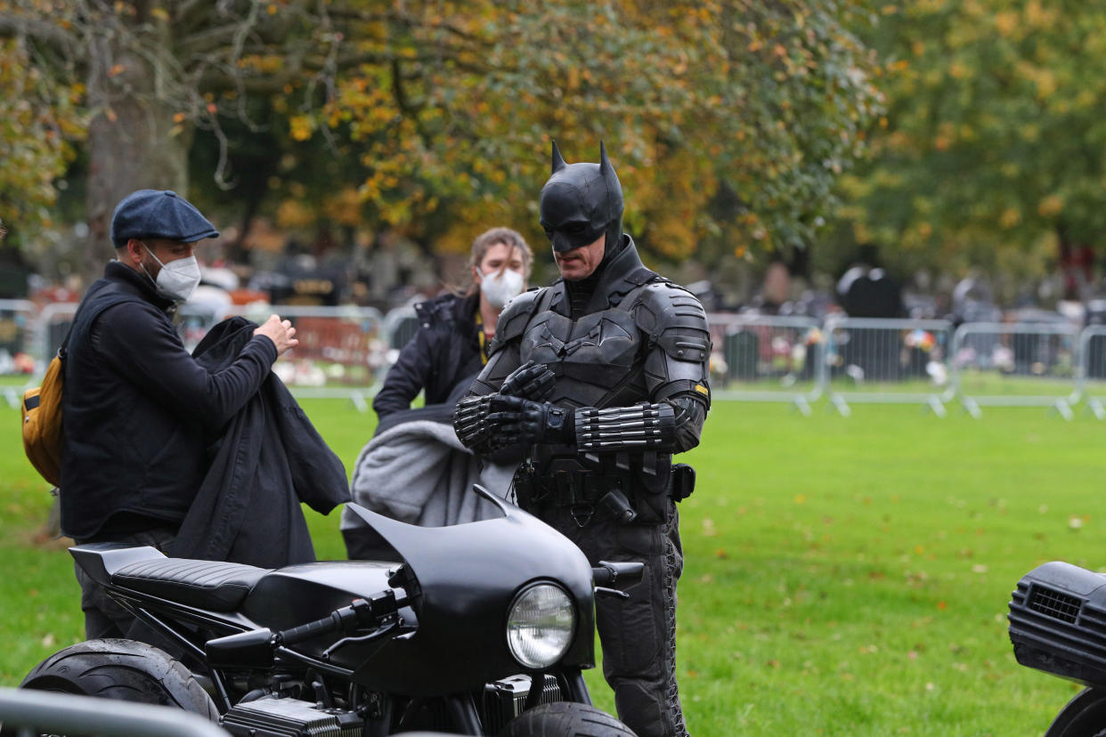 A man dressed as Batman gets on a motorbike during the filming of The Batman taking place in Liverpool.