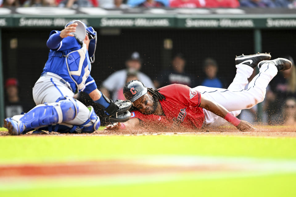 Cleveland Guardians' Josh Bell, right, scores against Kansas City Royals' Freddy Fermin, left, on a sacrifice fly hit by Myles Straw during the second inning of a baseball game, Saturday, July 8, 2023, in Cleveland. (AP Photo/Nick Cammett)