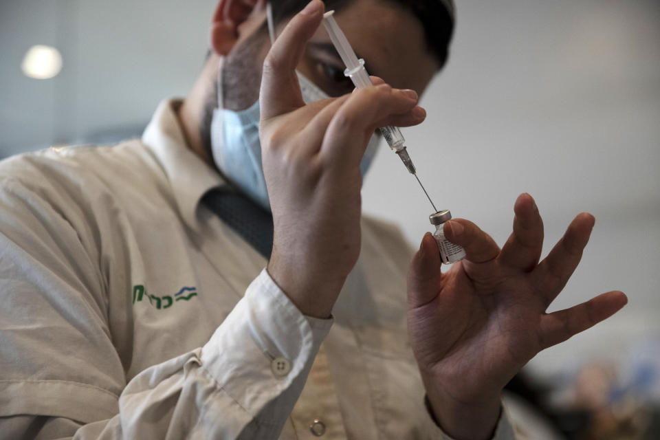 A medical worker prepares a vial of the Pfizer coronavirus vaccine at Clalit Health Service's center in the Cinema City complex in Jerusalem, Wednesday, Sept. 22, 2021. Israel is pressing ahead with its aggressive campaign of offering coronavirus boosters to almost anyone over 12 and says its approach was further vindicated by a U.S. decision to give the shots to older patients or those at higher risk. (AP Photo/Maya Alleruzzo)