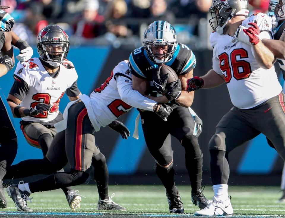 Carolina Panthers running back Chuba Hubbard, right, is tackled by Tampa Bay Buccaneers safety Ryan Neal at the Bank of America Stadium in Charlotte, N.C., on Sunday, January 7, 2024.