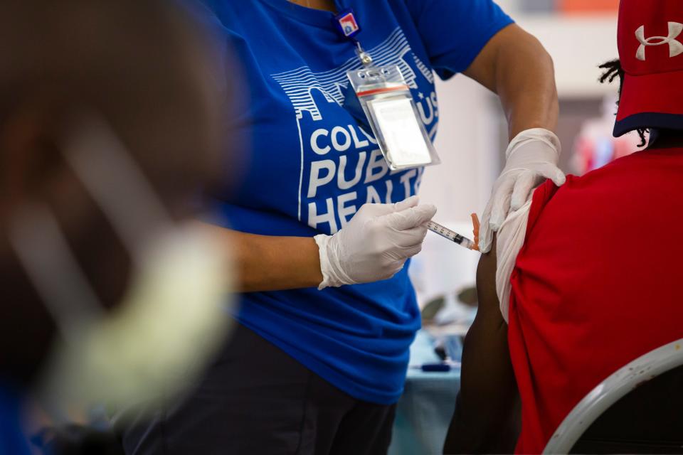 A patient receives their COVID-19 vaccination shot at Sullivant Gardens Community Center in Columbus, Ohio.