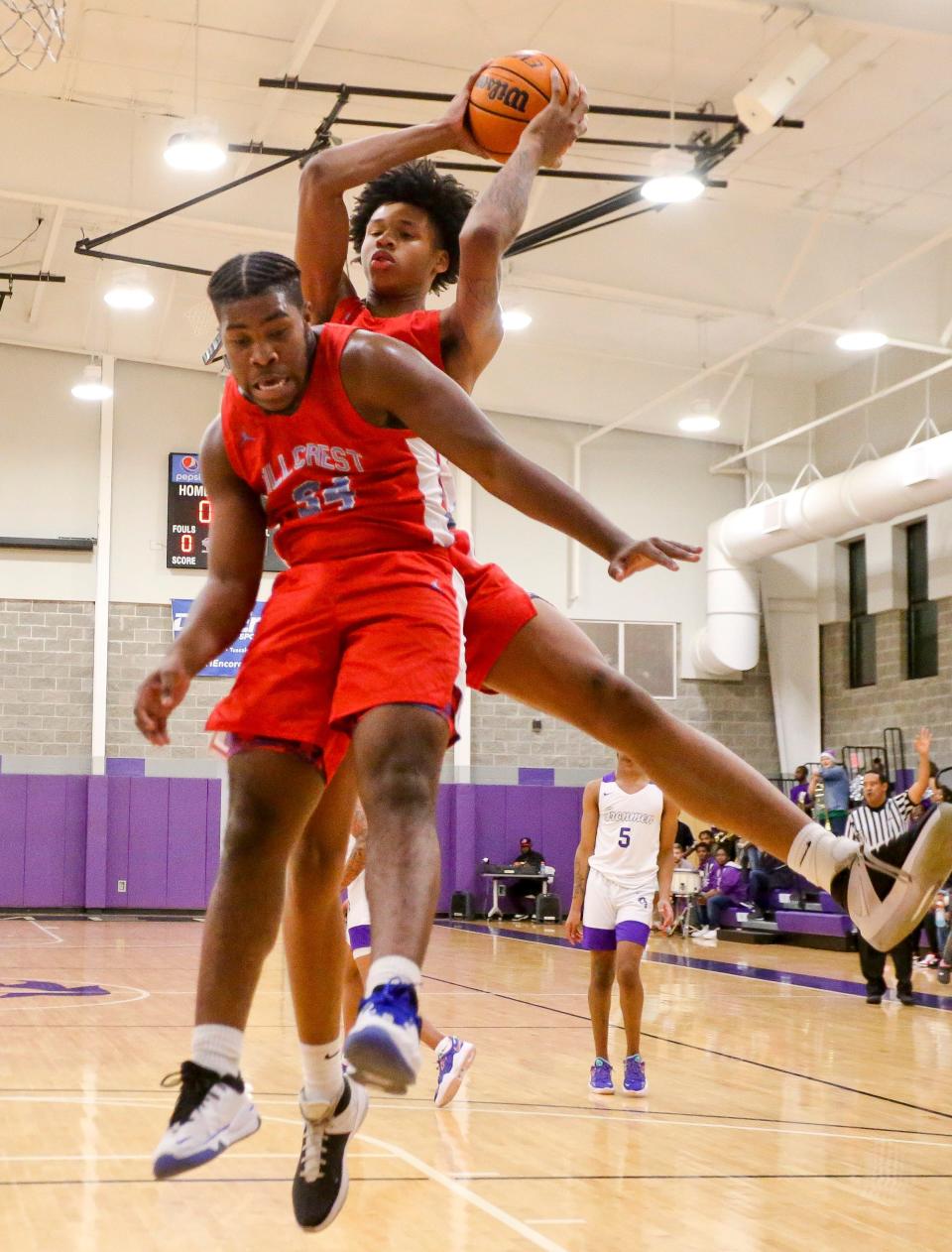 Hillcrest forward Cam Knox (34) and Hillcrest forward Shah Hall (21) pull a rebound as they play at Holt High School Thursday, Dec. 16, 2021. [Staff Photo/Gary Cosby Jr.]