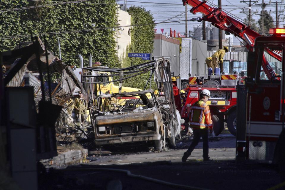 Los Angeles firefighters mop up damage from a fire that severely damaged a freeway at an Interstate 10 overpass in an industrial zone near downtown Los Angeles on Saturday, Nov. 11, 2023. Authorities say firefighters have mostly extinguished a large blaze that burned trailers, cars and other things in storage lots beneath a major highway near downtown Los Angeles, forcing the temporary closure of the roadway. (AP Photo/Richard Vogel)