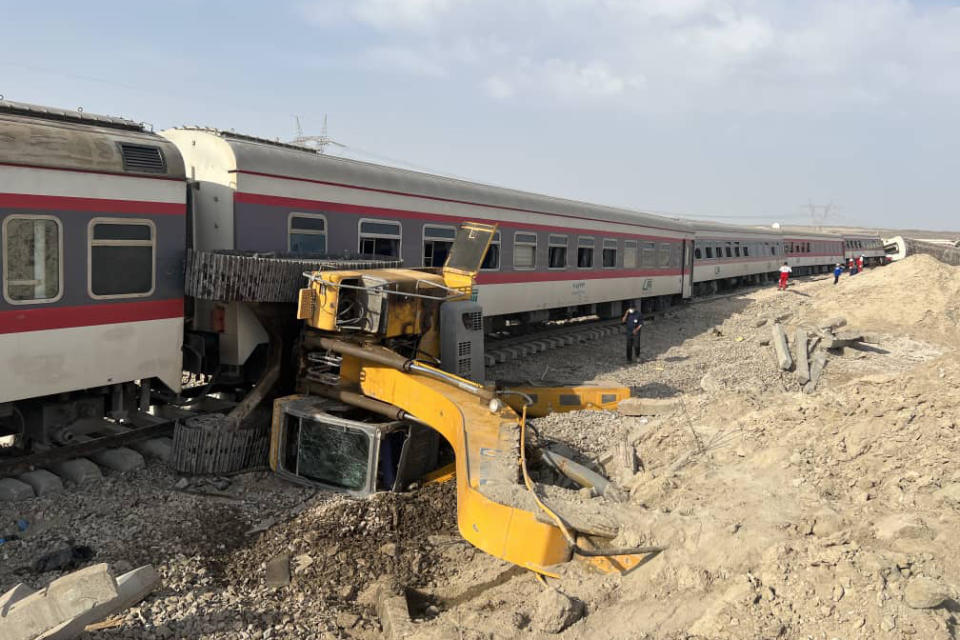 This photo provided by Iranian Red Crescent Society, shows the scene where a passenger train partially derailed near the desert city of Tabas in eastern Iran, Wednesday, Iran, Wednesday, June 8, 2022. (Iranian Red Crescent Society via AP)