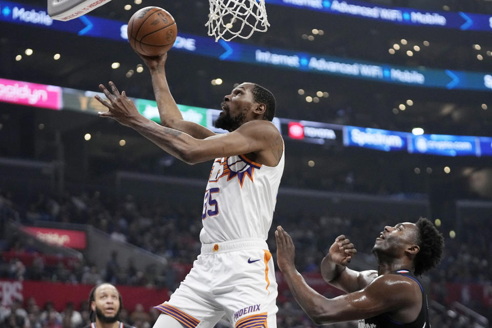 Phoenix Suns forward Kevin Durant, left, shoots as Los Angeles Clippers guard Kobe Brown defends during the first half of an NBA basketball game Wednesday, April 10, 2024, in Los Angeles. (AP Photo/Mark J. Terrill)