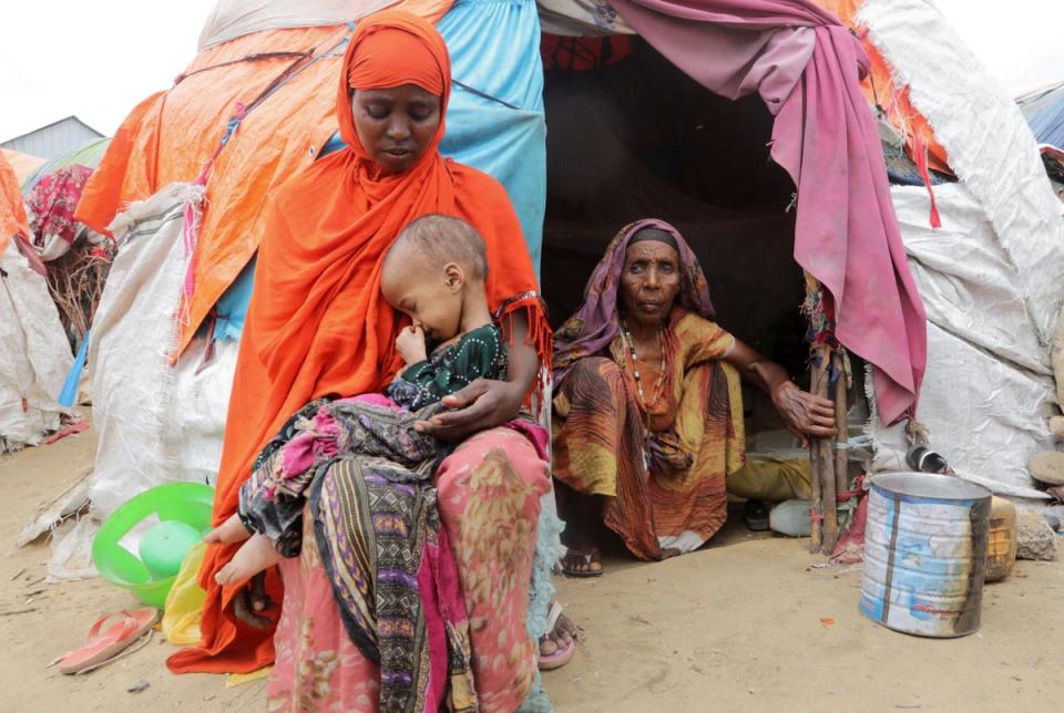 Buney Aayow Ibrahim, a Somali woman affected by the worsening drought due to failed rainy seasons, holds her child Sadia Salas Abdi, 3, as her grandmother Habiba Osman looks on, outside their makeshift shelter at the Alla Futo camp for internally displaced people, in the outskirts of Mogadishu (REUTERS)