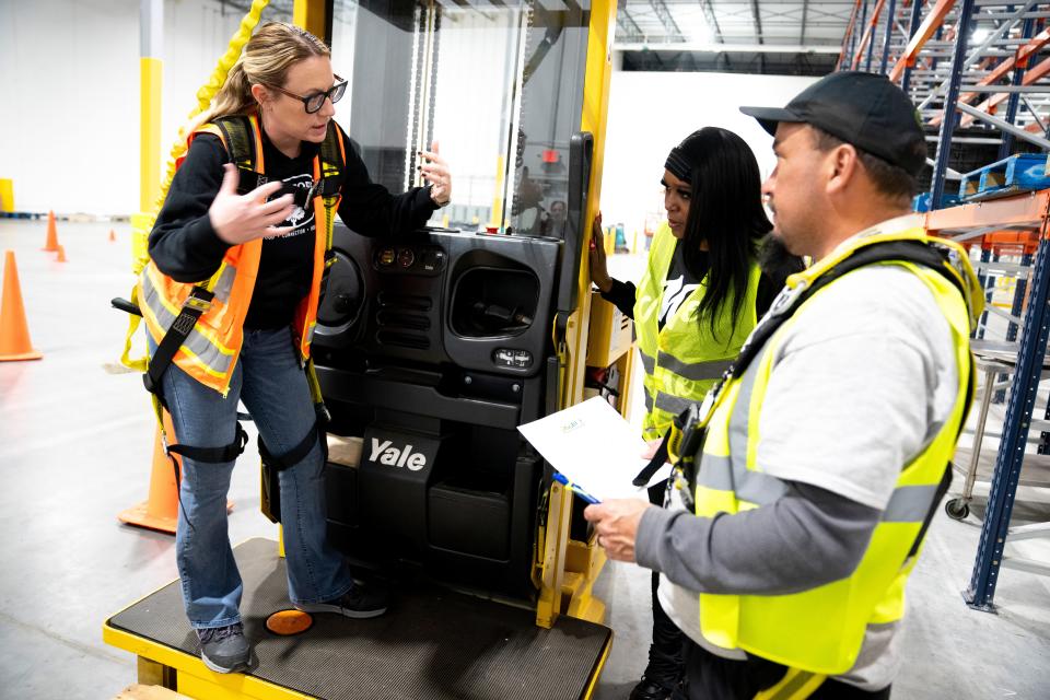 Katie Young, LIFT program manager, speaks with Delonya Beal and Christopher Glass during a program class.