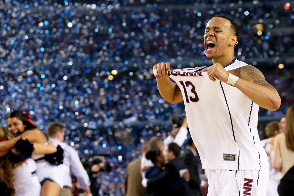 <p>Then: The 2014 tournament wasn’t Shabazz Napier’s first rodeo. As a freshman, Napier supported UConn phenom Kemba Walker to win the title in 2011. He established a remarkable reputation through his sophomore and junior years. Napier even perservered with the team despite coach Jim Calhoun’s departure in 2012 and the Huskies 2013 ban for academic eligbility. Connecticut danced their way through Michigan State and Florida, with an ultimate victory over Kentucky. Napier was named Outstanding Player of the Year and averaged 18.0 points, 5.9 rebounds, 4.9 assists, and 1.8 steals per game.<br>Now: Napier entered the 2014 NBA Draft and selected 24th overall by the Hornets, eventually being subsequently traded to the Heat later that night. In 2015, he was traded to Orlando and by the following year was traded to Portland. Napier remained with the Blazers from 2016-2018, until his trade to the Brooklyn Nets. </p>