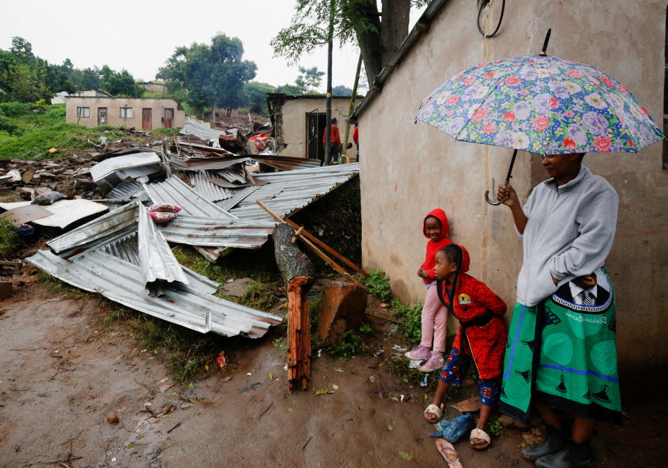 People stand near the remains of a building destroyed during flooding at the KwaNdengezi Station, near Durban, South Africa, April 16, 2022. / Credit: ROGAN WARD / REUTERS