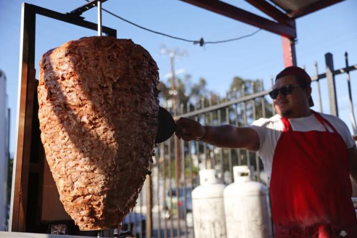 Los Angeles, CA - June 30:Jesus Koyot cooks the pork on a trompo at Avenue 26 Tacos in Little Tokyo on Thursday, June 30, 2022 in Los Angeles, CA. Taco trucks and stands are feeling the bite of inflation as meat and gas prices soar. (Dania Maxwell / Los Angeles Times)