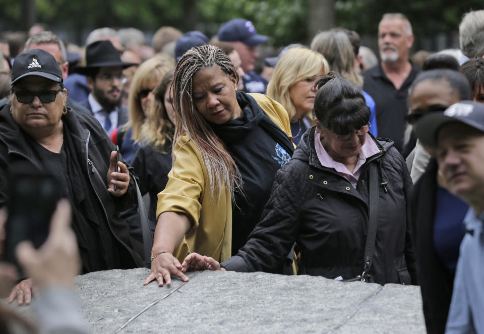 FILE- In this May 30, 2019 file photo, people gather around stones that are part of the new 9/11 Memorial Glade, on the grounds of the National September 11 Memorial and Museum in New York. On Sept. 11, 2019, when nearly 3,000 9/11 victims' names are read aloud on the memorial plaza, the half-dozen stacks of stone of the 9/11 Memorial Glade will quietly salute an untold number of people who aren't on the list. (AP Photo/Seth Wenig, File)