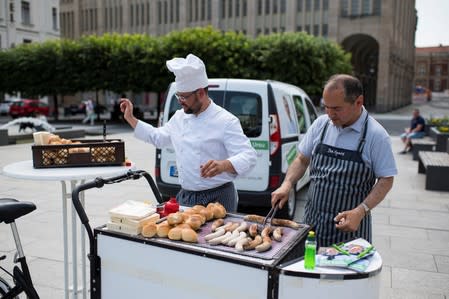 Octavian Ursu, of the Christian Democratic Union (CDU), a Romanian who moved to Germany in 1990, grils a bratwurst during local elections campaign on the Marienplatz in Goerlitz