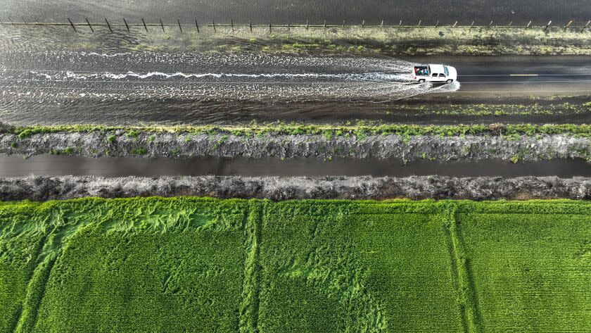 San Joaquin Valley, CA, Thursday, March 30, 2023 - A vehicle braves the flooded Garces Highway as the Tulare Lake basin continues to swell following record rainfall. (Robert Gauthier/Los Angeles Times)