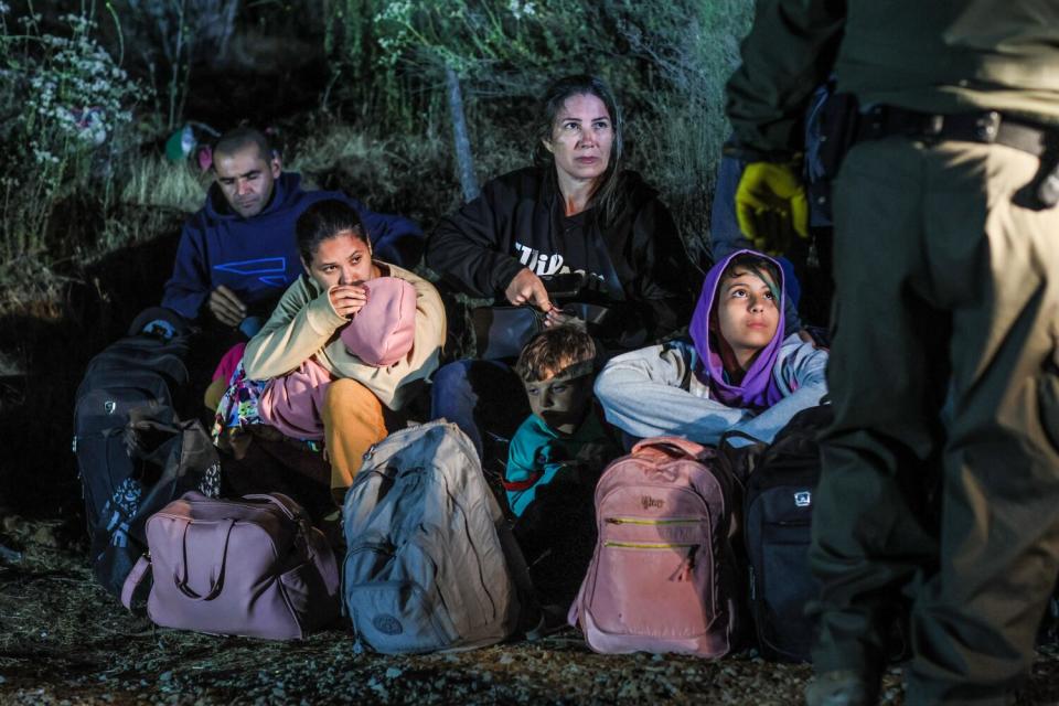 Migrants wait to board border patrol vehicles near Campo Rd. after crossing the US/Mexco border.