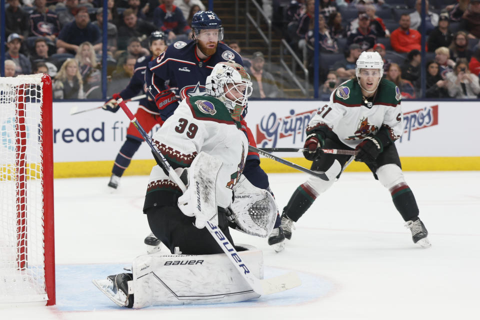 Arizona Coyotes' Connor Ingram, center, makes a save as teammate Troy Stecher, right, and Columbus Blue Jackets' Jakub Voracek look for the rebound during the second period of an NHL hockey game Tuesday, Oct. 25, 2022, in Columbus, Ohio. (AP Photo/Jay LaPrete)