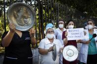 Respiratory Hospital INERAM health workers bang pots and hold up the Spanish message "We want supplies! Be strong INERAM!," to demand more materials for the ICU, outside their hospital in Asuncion, Paraguay, Wednesday, March 3, 2021, the day after INERAM Director Felipe Gonzalez resigned. Without vaccines or basic drugs to combat COVID-19, Paraguay's main public hospitals became unable to receive patients in intensive care units on Wednesday. (AP Photo/Jorge Saenz)