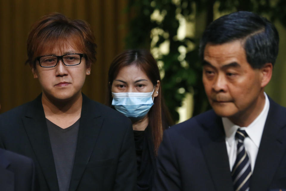 Hong Kong's leader, Chief Executive Leung Chun-ying, right, speaks as hostage survivor Yik Siu-ling, center, and Tse Chi-kin, left, brother of killed hostage victim Masa Tse Ting-chunn listen during a news conference in Hong Kong Wednesday, April 23, 2014. Hong Kong and the Philippines reached a compromise Wednesday over Hong Kong's demands for an apology for the families of eight tourists killed in a bungled response to a 2010 Manila hostage-taking that soured relations. (AP Photo/Kin Cheung)