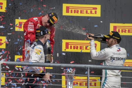 Oct 21, 2018; Austin, TX, USA; Ferrari driver Kimi Raikkonen (center) of Finland celebrates winning the United States Grand Prix at Circuit of the Americas with Red Bull Racing driver Max Verstappen (left) of Netherlands and Mercedes driver Lewis Hamilton (right) of Great Britain. Mandatory Credit: Jerome Miron-USA TODAY Sports