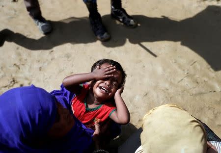 A Rohingya refugee child reacts as people queue for aid in a camp in Cox's Bazar, Bangladesh, September 22, 2017. REUTERS/Cathal McNaughton