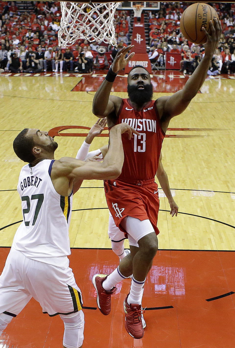Houston Rockets guard James Harden (13) drives to the basket as Utah Jazz center Rudy Gobert defends during the second half of Game 1 of an NBA basketball first-round playoff series, Sunday, April 14, 2019, in Houston. Houston won the game 122-90. (AP Photo/Eric Christian Smith)