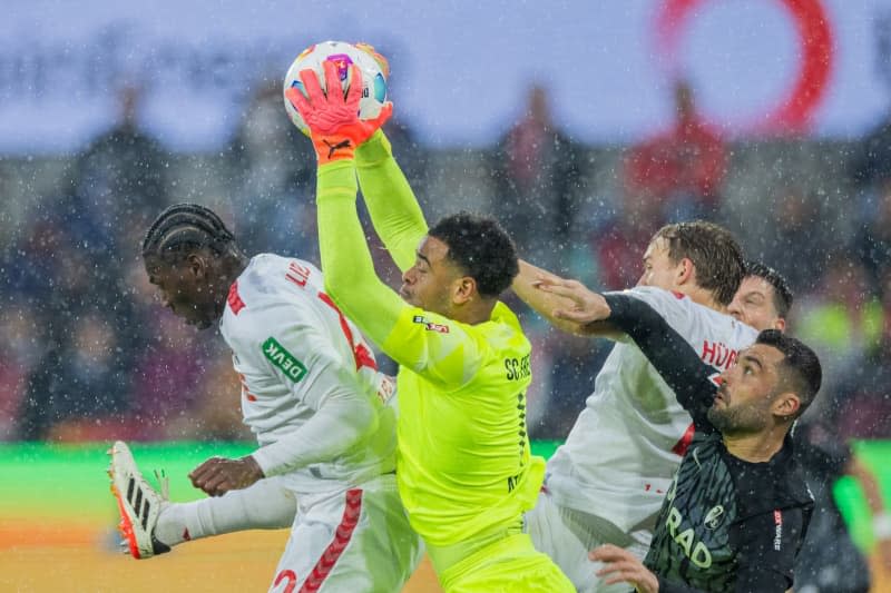 Freiburg goalkeeper Noah Atubolu gets to the ball before Cologne's Faride Alidou (L) during the German Bundesliga soccer match between 1. FC Cologne and SC Freiburg at RheinEnergieStadion. Rolf Vennenbernd/dpa