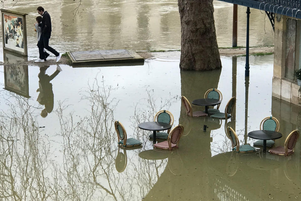 <p>Pedestrians walk along the Seine river on Jan. 28, 2018 in Chatou, a suburb of Paris, France. Water levels continued to rise after weeks of heavy rain in France. Photo from Pascal Le Segretain/Getty Images. </p>