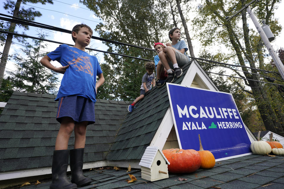 Kids watch the proceedings from the roof of a playhouse as Democratic gubernatorial candidate former Virginia Gov. Terry McAuliffe speaks to supporters during a rally in Richmond, Va., Sunday, Oct. 31, 2021. McAuliffe will face Republican Glenn Youngkin in the November election. (AP Photo/Steve Helber)