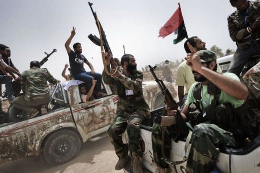 Libyan rebel fighters attend the funeral of seven fallen comrades in Benghazi