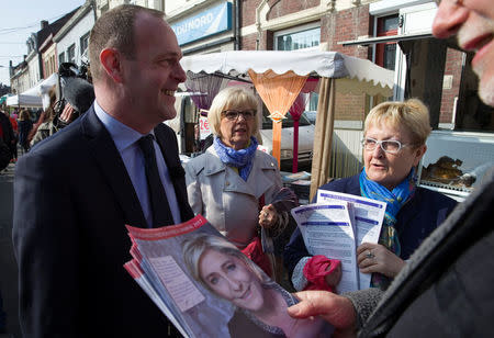 Steeve Briois, Mayor of Henin-Beaumont and one of the vice-presidents of French far right National Front political party, speaks with FN supporters of Marine Le Pen, French National Front (FN) political party leader and candidate for French 2017 presidential election, who distribute political leaflets at a local market in Henin-Beaumont, France, April 7, 2017. REUTERS/Pascal Rossignol