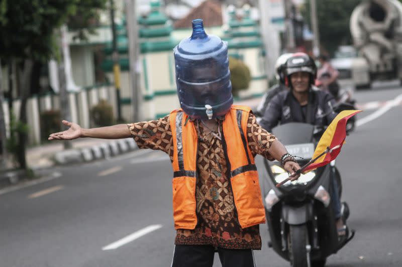 Ali Akbar, 52, a parking attendant, uses a plastic bottle for a face mask amid the coronavirus disease (COVID-19) outbreak in Yogyakarta