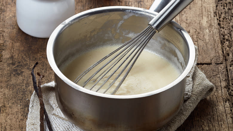 French whisk in saucepan with sauce