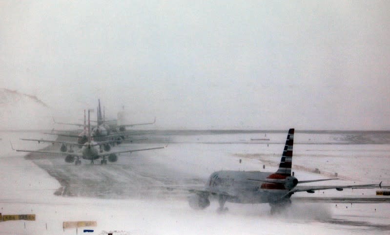 A line of jets wait to takeoff after a snowstorm at Denver International Airport