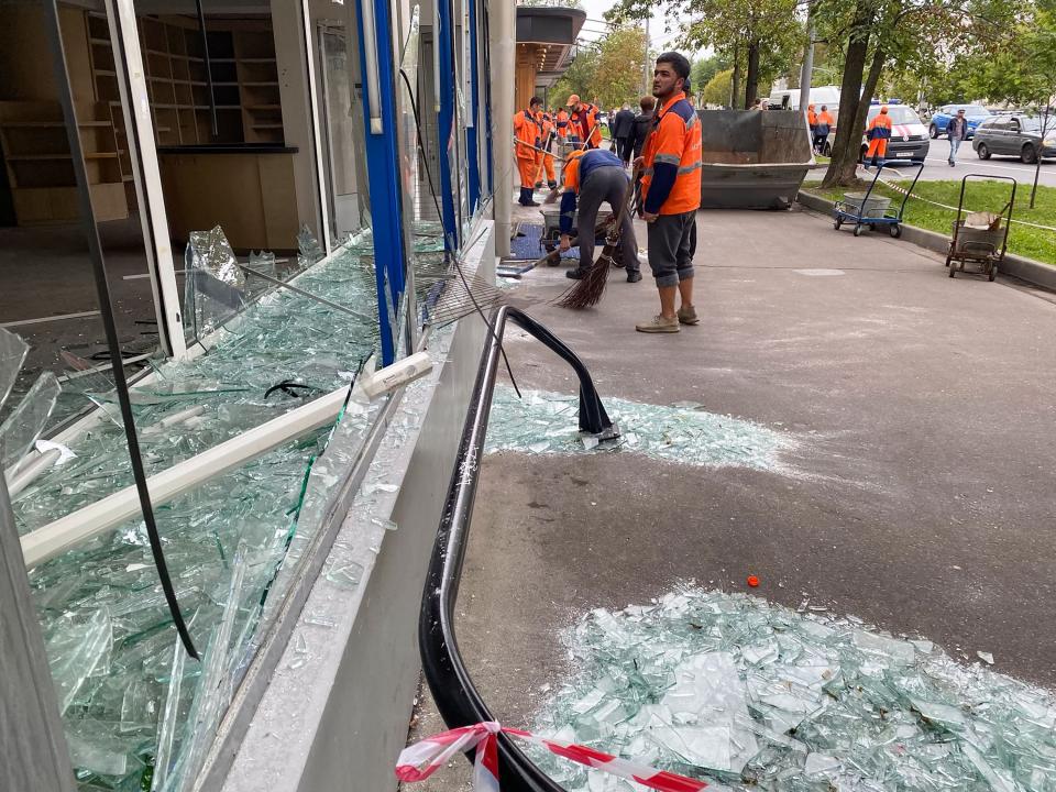 Municipal workers remove a shattered glass window at the scene of a reported drone attack on Komsomolsky Prospekt in Moscow on July 24, 2023.