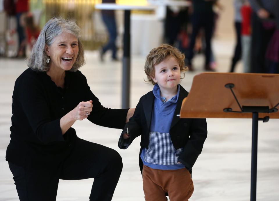 Bassoonist Beth Giacobassi helps her grandson Louis Giacobassi with his baton form at the conductor station prior to Milwaukee Symphony Orchestra's Dec. 17 family concert. The symphony has a number of shows scheduled through the winter.