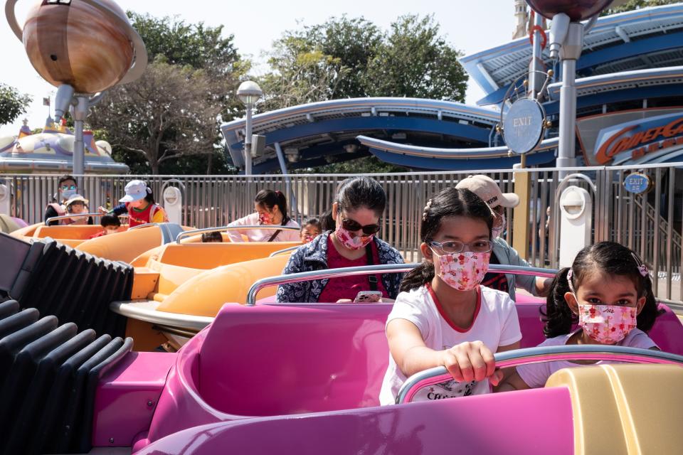 This image shows kids on a ride with face masks on.