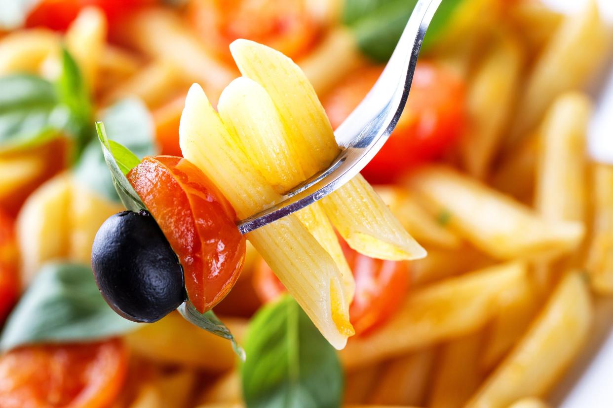 Penne pasta with cherry tomatoes, olives, and basil