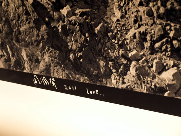 Chow Yun Fat autographs his work at the opening of the Louis Vuitton Island at Singapore’s MBS. (Yahoo! photo)