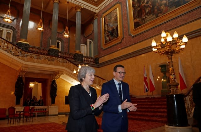 Theresa May and Mateusz Morawiecki applaud after hearing a choir sing during the consultations at Lancaster House