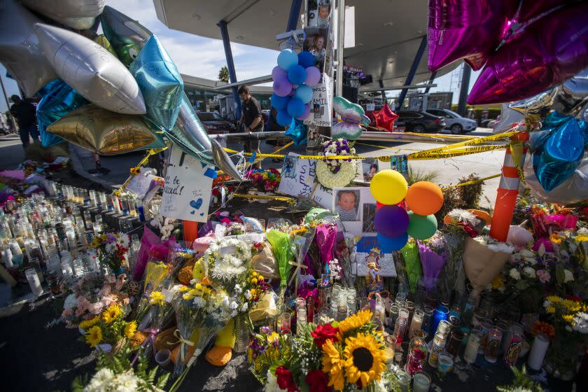 Los Angeles, CA - August 07: Candles, ballons, and flowers have been left at the sight of a deadly crash near La Brea and Slauson avenues on Sunday, Aug. 7, 2022, in the in Windsor Hills neighborhood of Los Angeles, CA. Family members, pastors, and community members came together to morn and pray together. The driver in Windsor Hills crash was released from the hospital into police custody. (Francine Orr / Los Angeles Times)