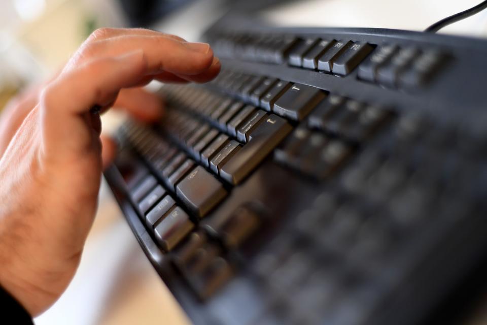 A person types on a keyboard.